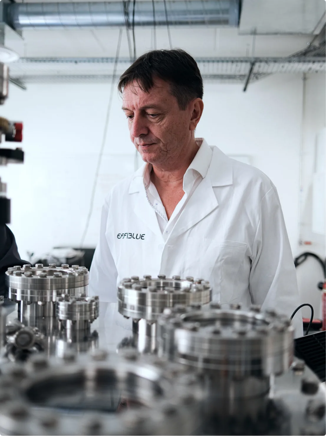 A person in an Effiblue lab coat in front of stainless steel equipment